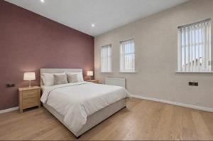 a bedroom with a large bed and two windows at Golf Let in Southport