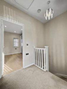 an empty room with a white door and a hallway at Golf Let in Southport +1 photo