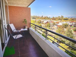 a balcony with two chairs and a table on it at Apartamento Vista Buena in Talca