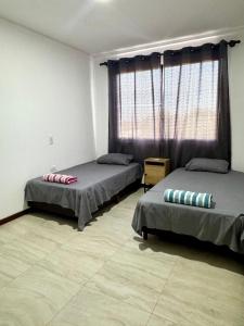 a bedroom with two beds and a large window at Departamento completo en zona Turística de Santa Cruz in Santa Cruz de la Sierra