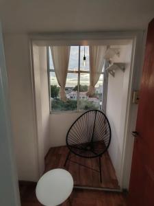 a room with a chair in front of a window at Departamento Zarate Centro in Zárate
