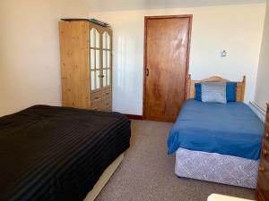 a bedroom with a bed and a dresser and a door at Azure Lodge in Bundoran