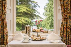 a table with a plate of food and a window at Friars Carse Country House Hotel in Dumfries