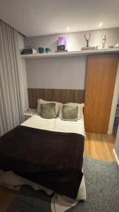 ein Schlafzimmer mit einem großen Bett mit Kissen darauf in der Unterkunft Flat gp moto in Goiânia