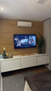 ein Wohnzimmer mit einem Flachbildfernseher an der Wand in der Unterkunft Flat gp moto in Goiânia