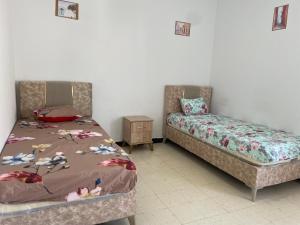 a bedroom with a bed and a couch and a table at Maison Fatima in Mahdia