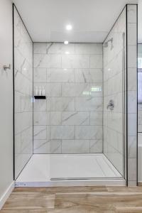 a shower with a glass door in a bathroom at Homeport Motel in Lunenburg +65 photos
