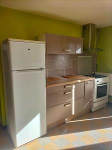 a kitchen with a white refrigerator and a stove at Maison de charme solognote in Neung-sur-Beuvron