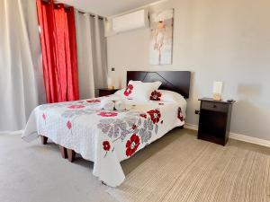 a bedroom with a bed with a red and white blanket at Apartamento Vista Buena in Talca