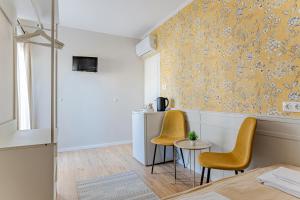 a room with two yellow chairs and a table at T7 Garden guest house in Siófok