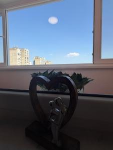 a statue of a heart in front of a window at MAAA Apartman in Tuzla