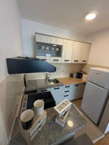 a small kitchen with a sink and a refrigerator at MAAA Apartman in Tuzla