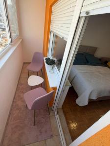 a small bedroom with a bed and a window at MAAA Apartman in Tuzla