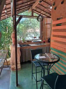 a kitchen with a table and chairs and a sink at Pátio FlorAção in Igatu