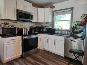 a kitchen with white cabinets and a black stove top oven at Villa Nemesio & Linsday 2 in Atlanta