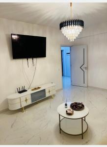 a living room with a tv and a table at Atlantis Suites Bragadiru Bucuresti Parcare gratuita Self checkin in Bragadiru +4 photos
