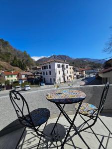 Ein Tisch und Stühle auf einem Balkon mit Blick auf eine Stadt in der Unterkunft SMARAGD Damir Antunovic-sobodajalec in Kobarid