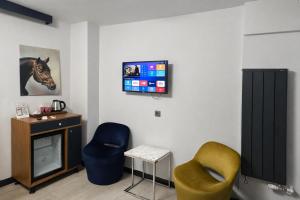 a room with two chairs and a tv on a wall at VAMA TAKSİM Hotel in Istanbul