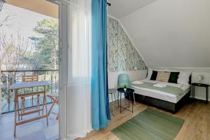 a bedroom with a bed and a balcony at T7 Garden guest house in Siófok