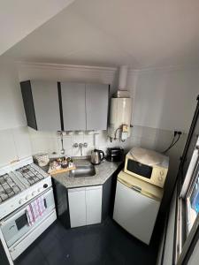 a small kitchen with a stove and a microwave at Corro 8 in Córdoba +26 photos