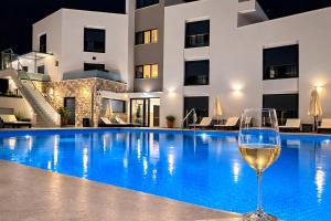 a glass of wine next to a swimming pool at night at Avis 1 in Igalo