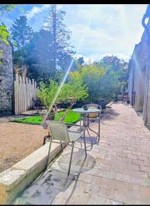 a patio with a table and chairs with a sprinkler at Loft Spa Prestige in Villampuy