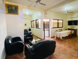 a living room with black leather chairs and a table at Sanga City in Bakel