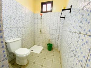 a bathroom with a toilet in a tiled room at Sanga City in Bakel