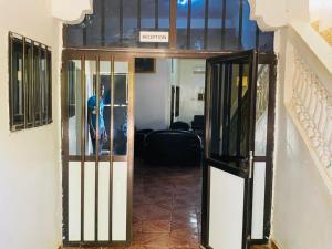 a hallway with a door with a person standing in it at Sanga City in Bakel +5 photos