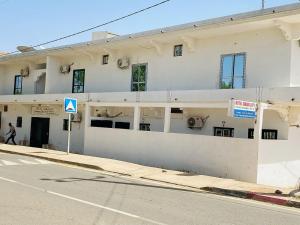 a white building on the side of a street at Sanga City in Bakel