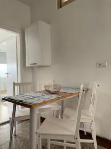 a kitchen with a wooden table and white chairs at Wohnung Karl-Marx 1 in Trier