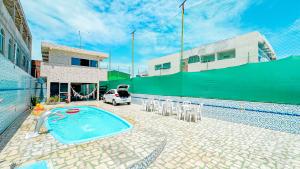 a pool with chairs and a car parked next to a building at Casa Espaço Gaibu in Cabo de Santo Agostinho