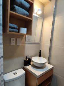 a bathroom with a sink and a toilet and towels at Apartamento Flores in Puno