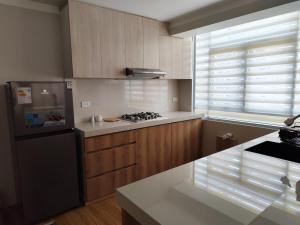 a kitchen with wooden cabinets and a stove top oven at Apartamento Flores in Puno