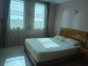 a bedroom with a large bed with a window at HOTEL AZOuR in Agadir