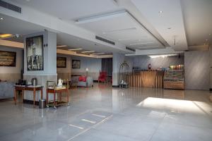a lobby with a waiting area with tables and chairs at دار ود للشقق المخدومة Dar Wed in Jeddah