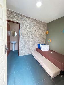 a bedroom with a bed and a bathroom with a sink at Casa Espaço Gaibu in Cabo de Santo Agostinho