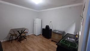 a kitchen with a refrigerator and a table and chairs at Casa inteira, Nações in Patrocínio +8 photos