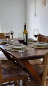 a wooden table with wine glasses and a bottle of wine at Beira Rio Casa Canastra in Vargem Bonita
