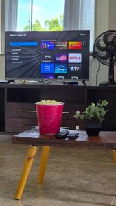 a red bucket sitting on a table in front of a tv at Beira Rio Casa Canastra in Vargem Bonita