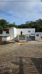 a building with a fence in front of a house at Beira Rio Casa Canastra in Vargem Bonita