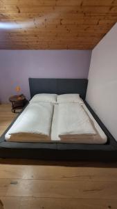 a large bed in a room with a wooden ceiling at Berg Glück Axams in Innsbruck