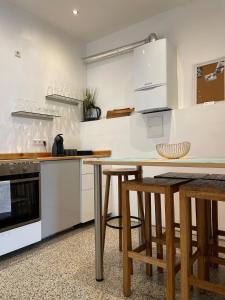 a kitchen with white cabinets and a wooden table at Wohnung Karl-Marx 2 in Trier