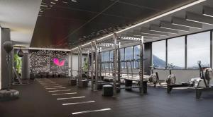 a gym with rows of machines and windows at Luxury loft for 2 to 4 people in Monterrey