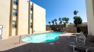 a swimming pool in front of a building at Walkable Location - 99 Steps to Beach - Pool apts in South Padre Island +69 photos
