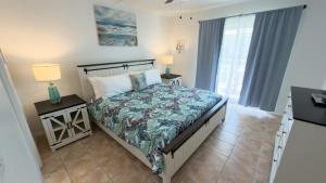 a bedroom with a bed and two tables with lamps at Walkable Location - 99 Steps to Beach - Pool apts in South Padre Island