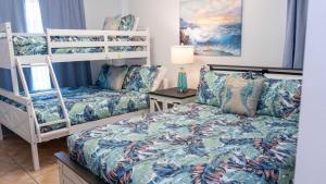 a bedroom with two bunk beds and a bed at Walkable Location - 99 Steps to Beach - Pool apts in South Padre Island