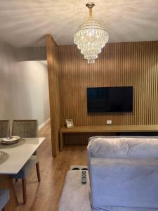 a living room with a couch and a chandelier at Meu cantinho in Dourados