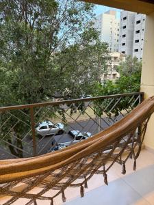 a hammock on a balcony overlooking a parking lot at Meu cantinho in Dourados