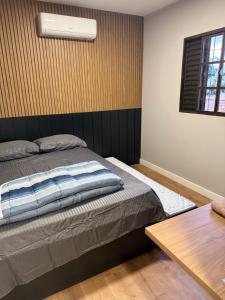 a bedroom with a bed and a table at Meu cantinho in Dourados